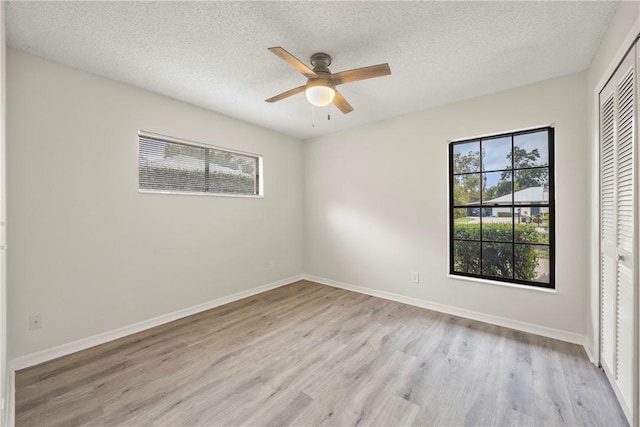 2821 21st Pl, Vero Beach, FL 32960 - unfurnished bedroom featuring multiple windows, a closet, wood finished floors, and a textured ceiling