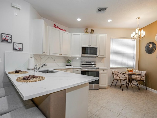 kitchen featuring appliances with stainless steel finishes, backsplash, white cabinets, decorative light fixtures, and kitchen peninsula