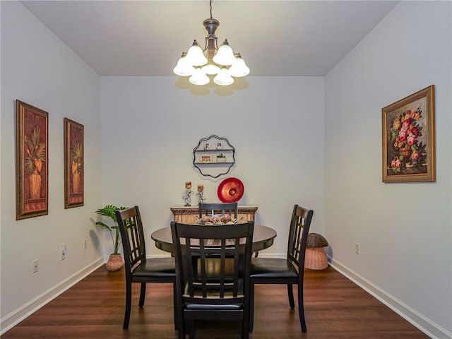 dining space with dark hardwood / wood-style flooring and a notable chandelier