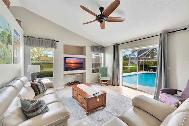 tiled living room with ceiling fan and lofted ceiling