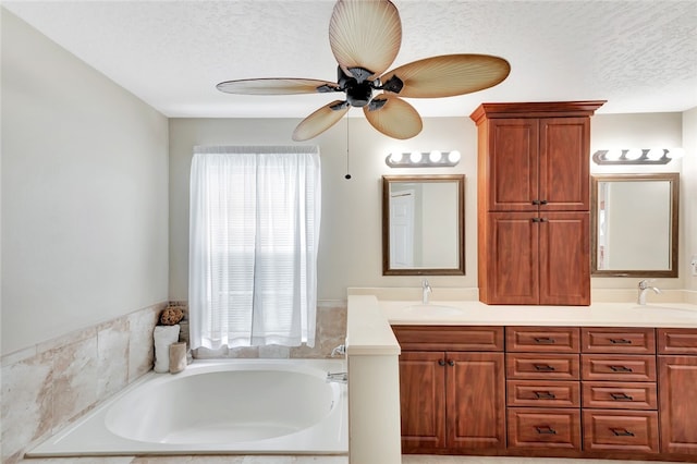 bathroom featuring vanity, a healthy amount of sunlight, a textured ceiling, and a tub