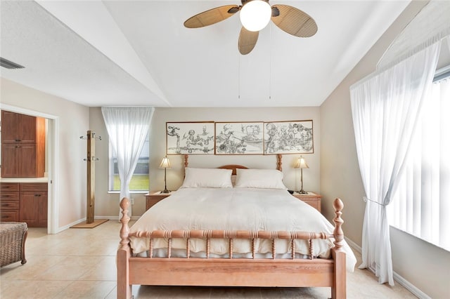 tiled bedroom featuring ensuite bath, ceiling fan, and lofted ceiling