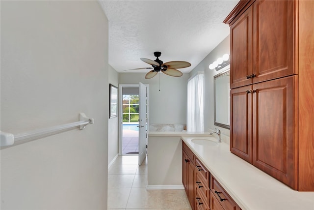 bathroom with tile patterned floors, ceiling fan, vanity, and a textured ceiling