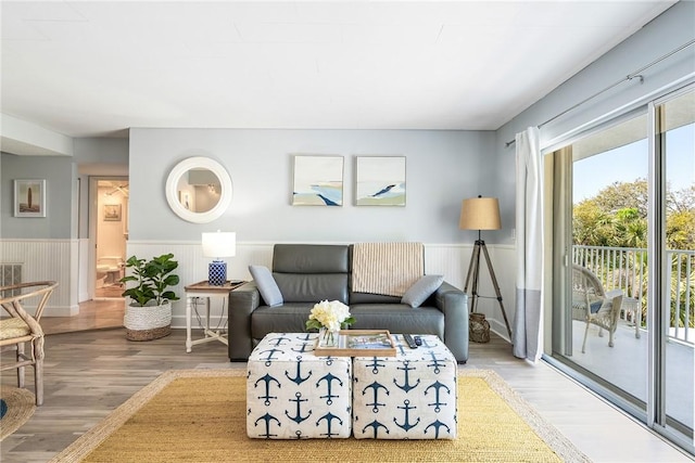 living area featuring light wood-type flooring and wainscoting