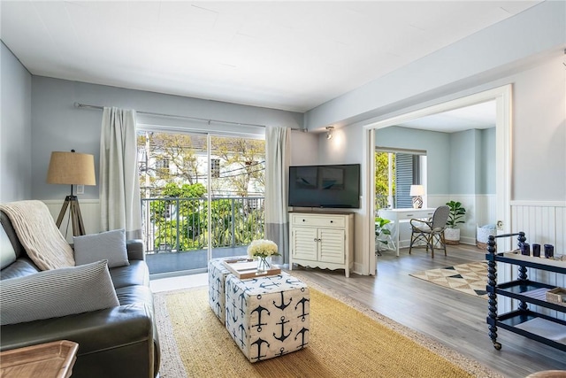 living area featuring a wainscoted wall and wood finished floors