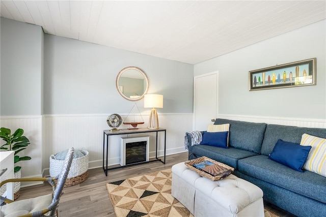 living area with wainscoting and wood finished floors