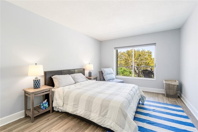 bedroom with wood finished floors and baseboards