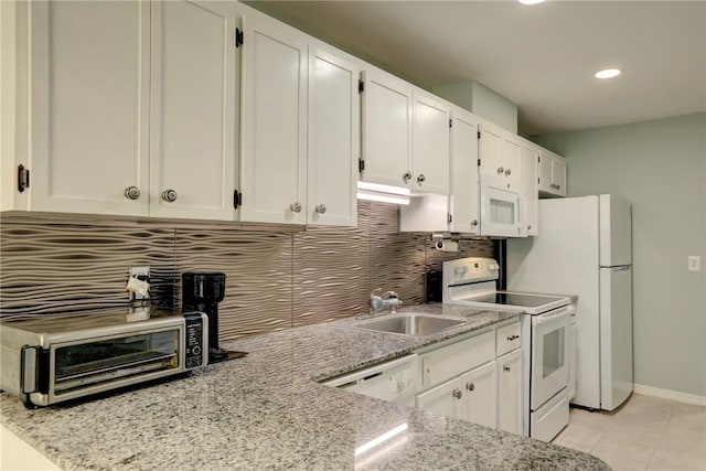 8520 US Highway 1 Unit 11E, Micco, FL 32976 - kitchen featuring light stone counters, white appliances, white cabinetry, backsplash, and a sink