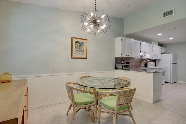 8520 US Highway 1 Unit 11E, Micco, FL 32976 - dining room with a chandelier, light tile patterned floors, visible vents, and a wainscoted wall