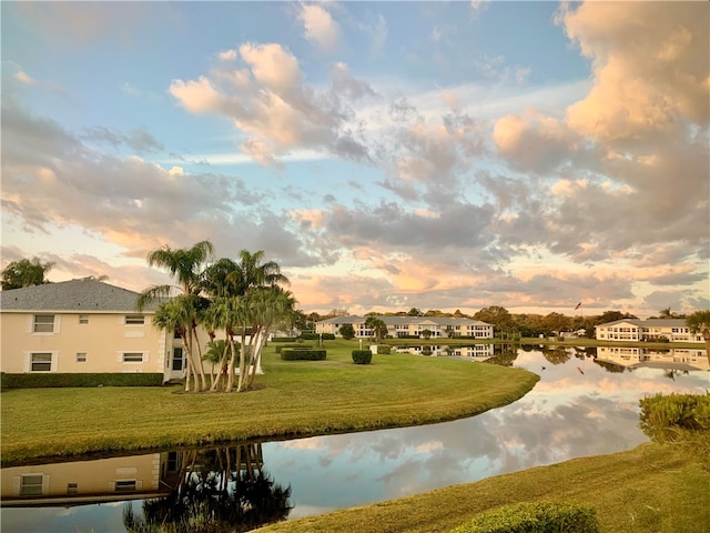 view of property's community featuring a lawn and a water view