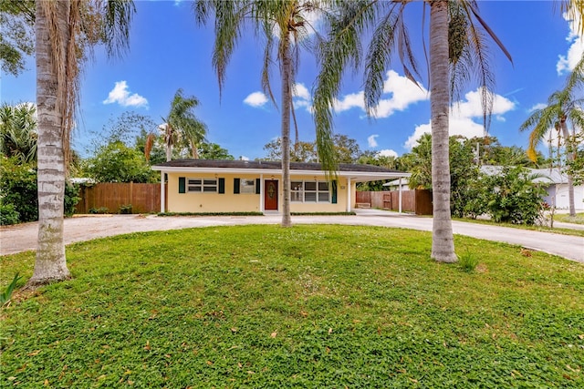 ranch-style house featuring a front lawn and a carport