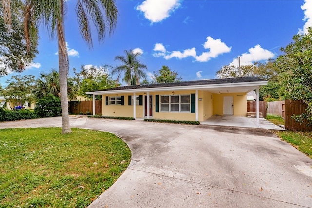 ranch-style home featuring a carport and a front yard