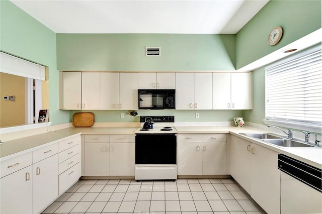 kitchen with white cabinets, light tile patterned flooring, white appliances, and sink