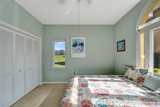 bedroom featuring ceiling fan, a closet, and light carpet