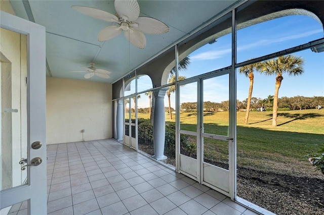 unfurnished sunroom featuring ceiling fan