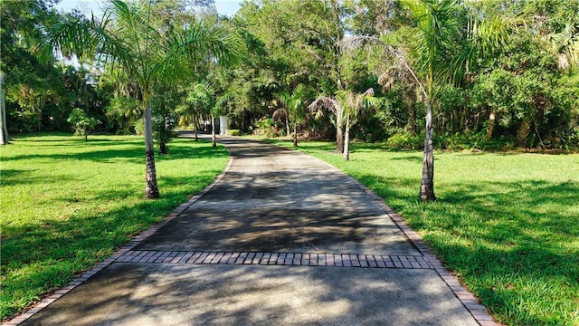 6235 4th St, Vero Beach, FL 32968 - surrounding community with asphalt driveway and a lawn