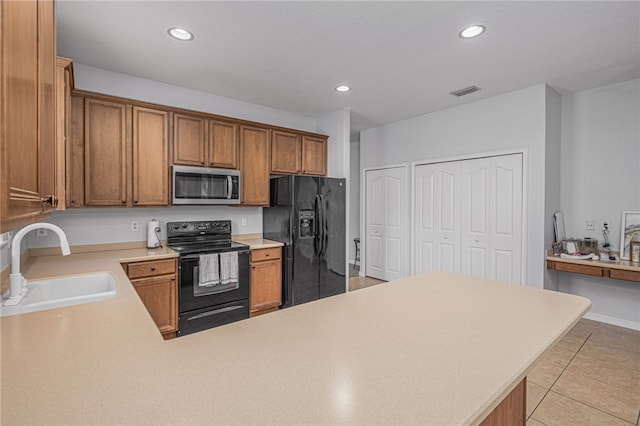 kitchen featuring light tile patterned flooring, kitchen peninsula, sink, and black appliances