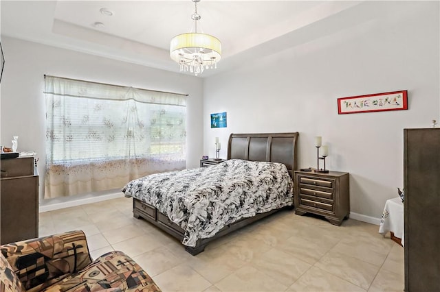 bedroom featuring a tray ceiling and an inviting chandelier