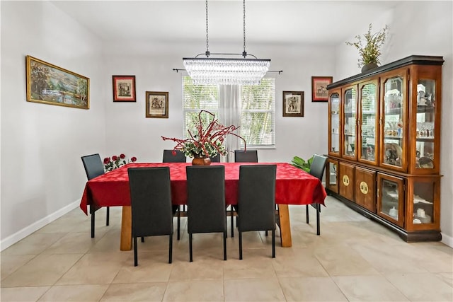 dining space with light tile patterned floors and an inviting chandelier