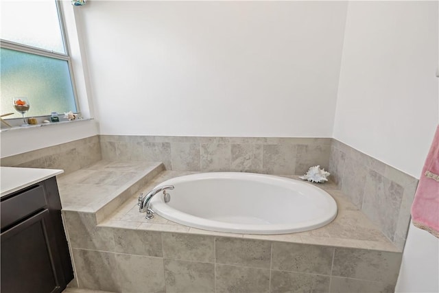 bathroom featuring vanity and a relaxing tiled tub