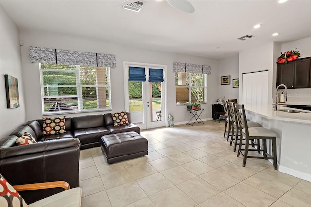 living room with light tile patterned floors, french doors, and sink