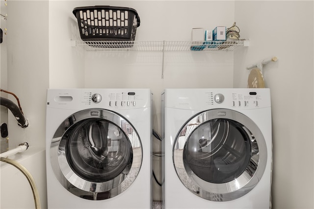 clothes washing area with washing machine and dryer