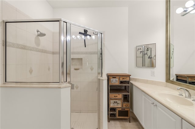 bathroom with walk in shower, tile patterned flooring, and vanity