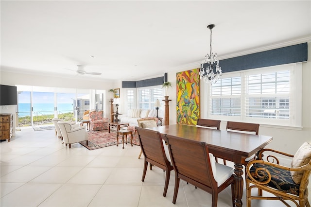 tiled dining room with ceiling fan with notable chandelier and ornamental molding