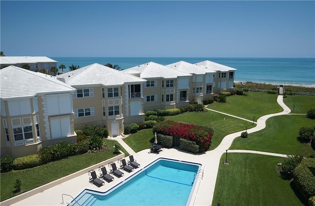 view of swimming pool featuring a water view and a patio area