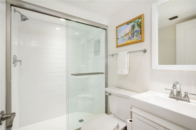 bathroom with vanity, toilet, and a shower with shower door