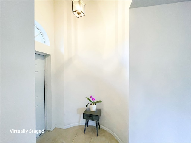 corridor with baseboards and light tile patterned flooring