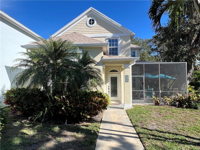 view of front of home featuring a front lawn and a sunroom