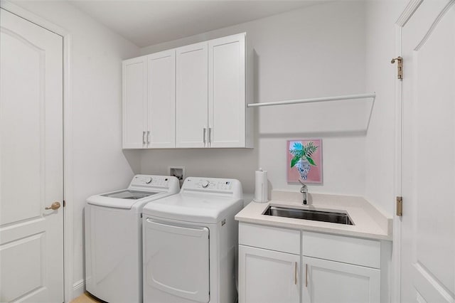 washroom with cabinets, sink, and washing machine and dryer