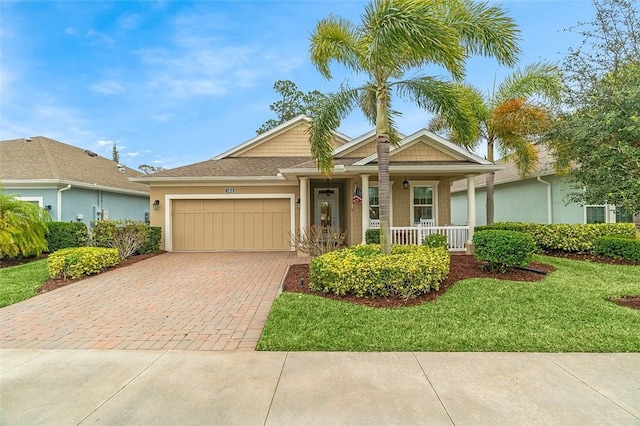 ranch-style house with a garage, covered porch, and a front lawn