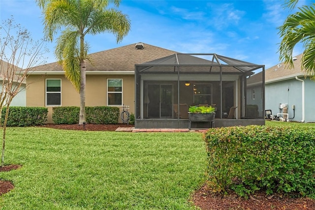 rear view of property with a yard and glass enclosure