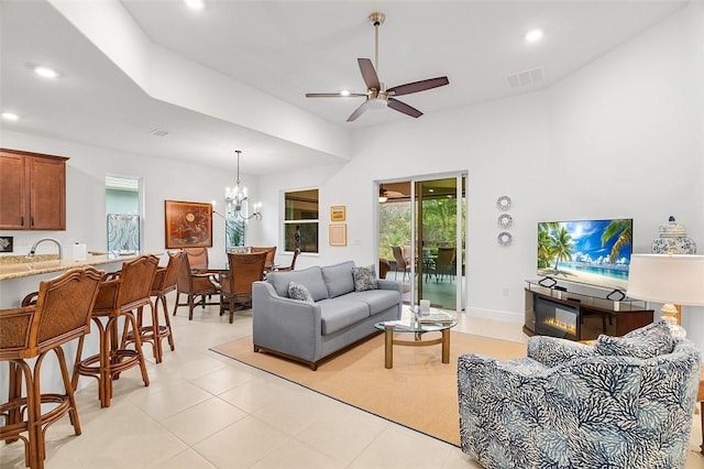 living room with ceiling fan with notable chandelier, sink, and light tile patterned floors