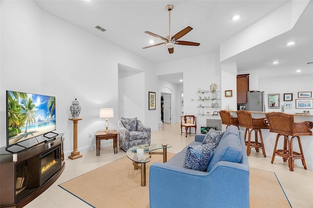 living room with ceiling fan and light tile patterned flooring