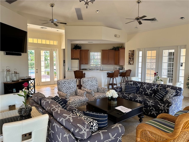 tiled living room featuring crown molding, sink, and a healthy amount of sunlight