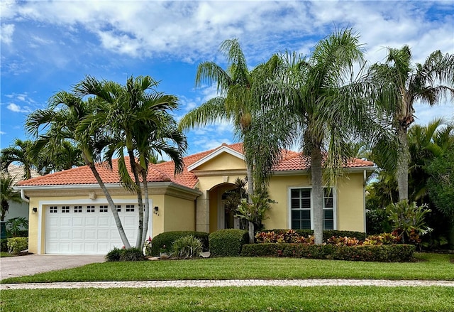 mediterranean / spanish house with a front yard and a garage