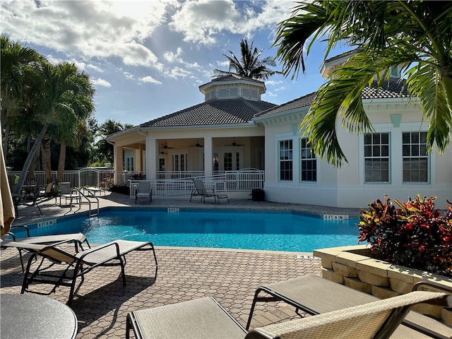 view of swimming pool with a patio area, ceiling fan, and french doors