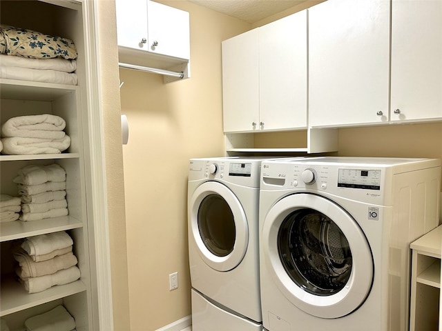 washroom with separate washer and dryer and cabinets