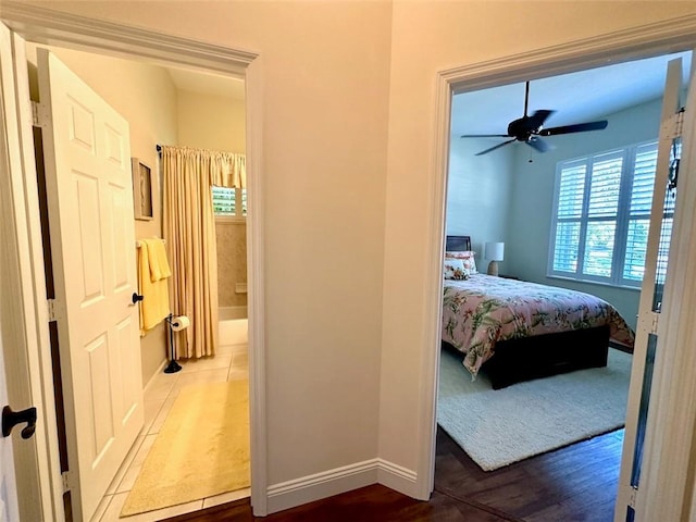 944 Island Club Sq, Vero Beach, FL 32963 - bedroom with baseboards, connected bathroom, wood finished floors, and ceiling fan