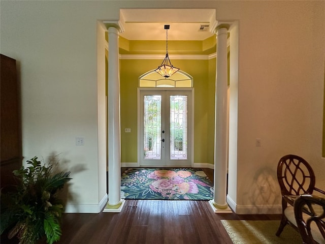 foyer entrance featuring french doors, dark hardwood / wood-style floors, decorative columns, and ornamental molding