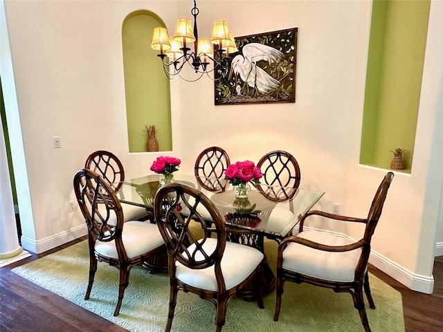944 Island Club Sq, Vero Beach, FL 32963 - dining area featuring wood finished floors, baseboards, a chandelier, and arched walkways