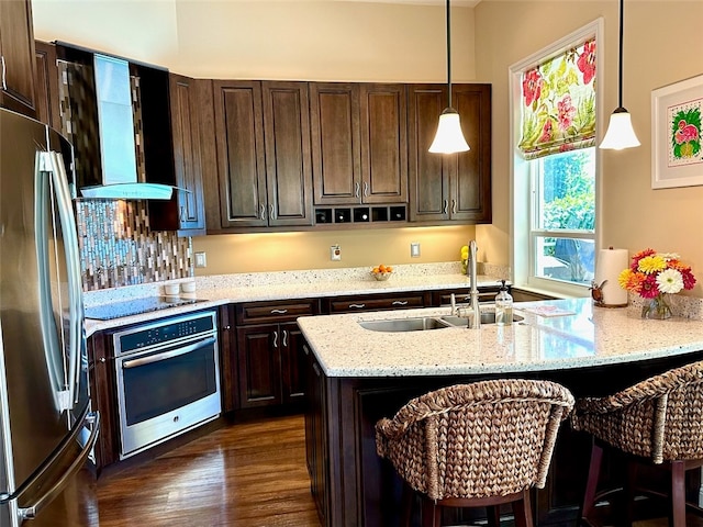 kitchen with pendant lighting, light stone countertops, dark wood-type flooring, and appliances with stainless steel finishes