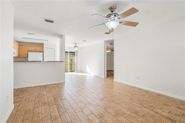 unfurnished living room featuring ceiling fan and light wood-type flooring