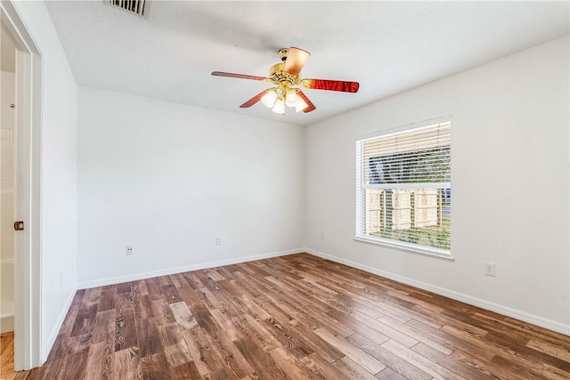 spare room with dark hardwood / wood-style floors and ceiling fan