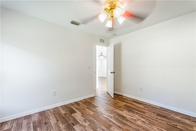 unfurnished room with dark hardwood / wood-style flooring and ceiling fan