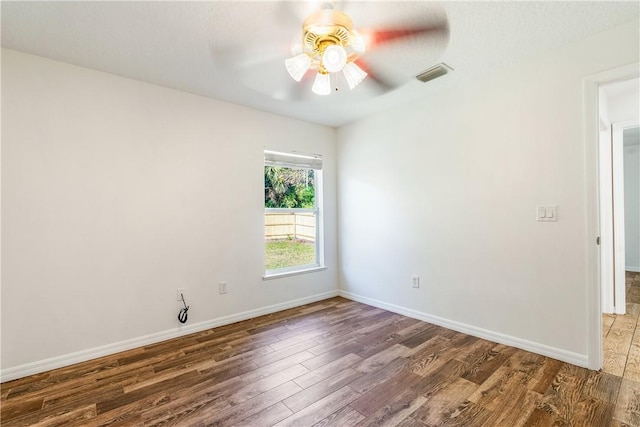 spare room featuring ceiling fan and dark wood-type flooring