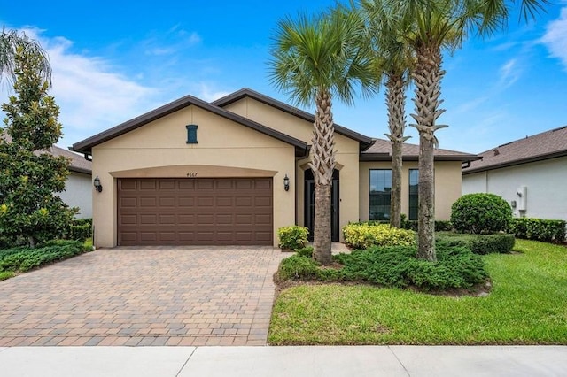 ranch-style home with a garage and a front lawn